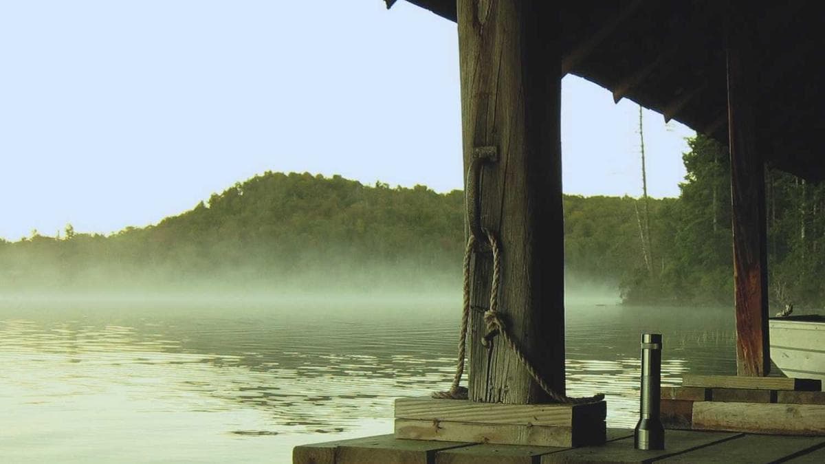 Sales manager coaching a team member one-on-one with a laptop showing CRM data